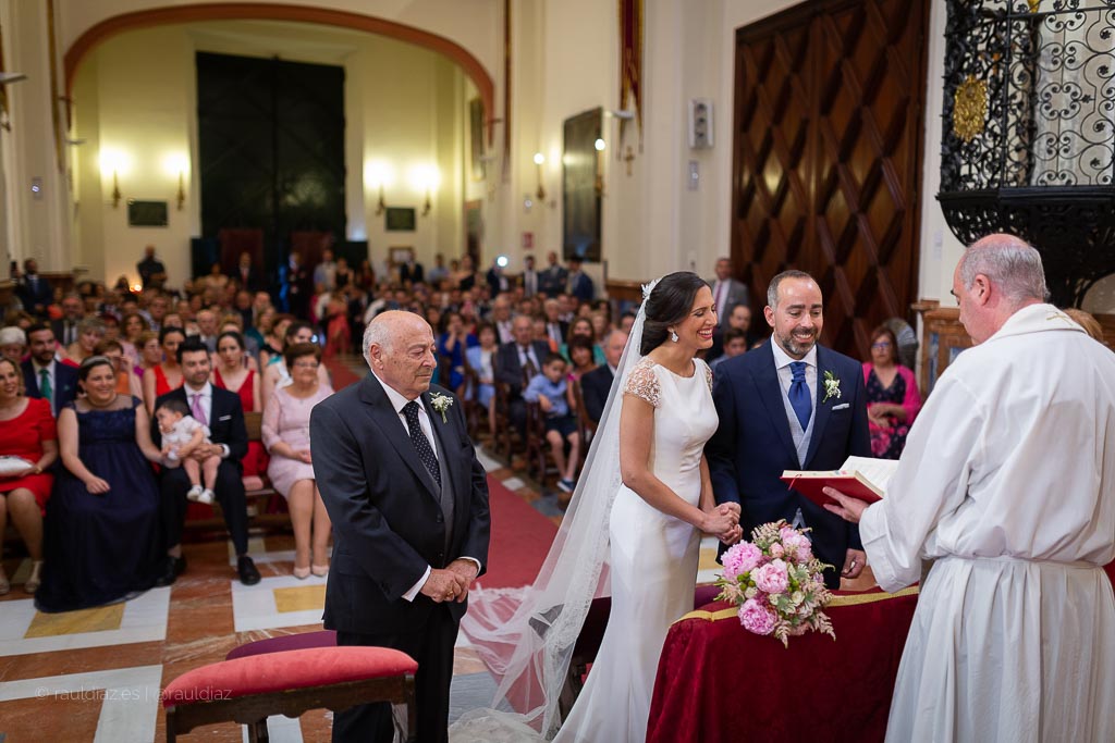 La pareja sonríe durante la ceremonia ante sus familiares