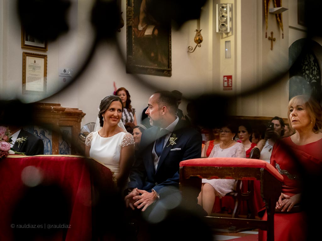 Mirada entre la pareja durante la ceremonia a través de una reja
