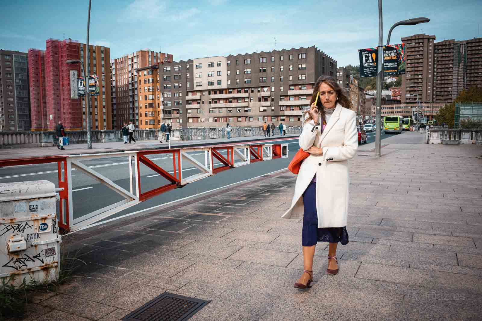 Mujer caminando y hablando por teléfono en una calle de Bilbao